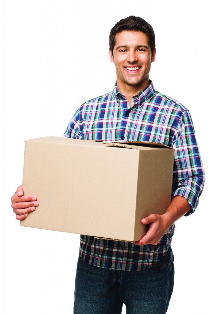 Portrait of a happy young man carrying cardboard box. Vertical shot. Isolated on white.
