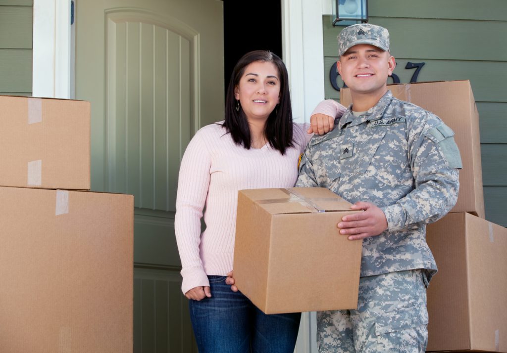 Military couple moving out of home with boxes